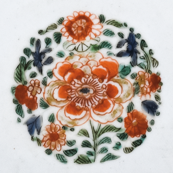 圖為清代五彩花卉紋碟細節(jié)圖，碟心主題紋飾為團花圖，紅花綠葉，相映成趣。（來源：廣州十三行博物館）